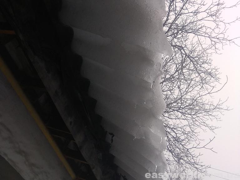 Ледяной снег над головой свисающий с крыши